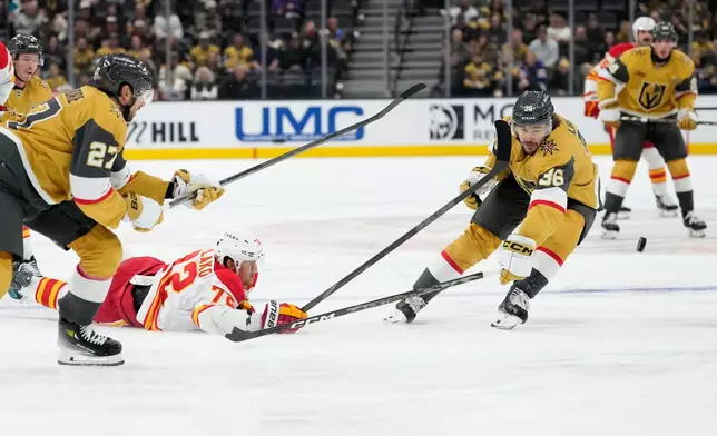 Calgary Flames right wing Maxim Tsyplakov (72) and Vegas Golden Knights center Raphael Lavoie (36) battle for the puck during the first period of an NHL hockey game Thursday, Oct. 15, 2026, in Las Vegas. (AP Photo/John Locher)