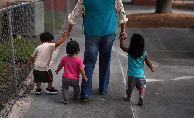 A teacher escorts young children back to their classroom at a Head Start preschool in Immokalee, Fla., Thursday, Sept. 10, 2026. (AP Photo/Rebecca Blackwell)