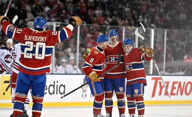 Montreal Canadiens' Kaiden Guhle (21) celebratesafter his goal against the Winnipeg Jets with Mike Matheson (8), Cole Caufield (13) and Juraj Slafkovsky (20) during the second period of the NHL Heritage Classic hockey game in Winnipeg, Manitoba, Sunday, Oct. 25, 2026. (Fred Greenslade/The Canadian Press via AP)