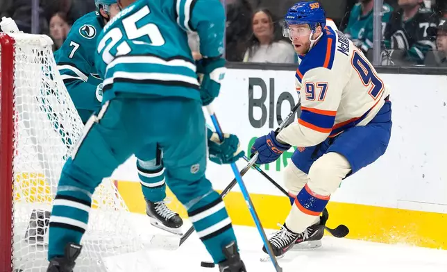 Edmonton Oilers center Connor McDavid (97) looks to pass the puck against San Jose Sharks defenseman Darnell Nurse (25) during the second period of an NHL hockey game in San Jose, Calif., Saturday, Oct. 10, 2026. (AP Photo/Tony Avelar)