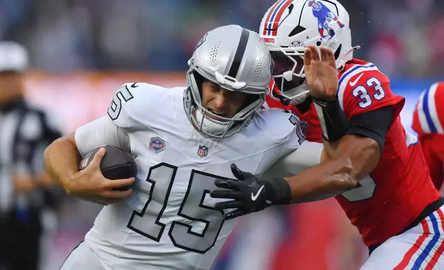 Las Vegas Raiders quarterback Fernando Mendoza (15) runs with the ball as New England Patriots safety Mike Brown (33) defends during the second half of an NFL football game in Foxborough, Mass., Sunday, Oct. 11, 2026. (AP Photo/Steven Senne)