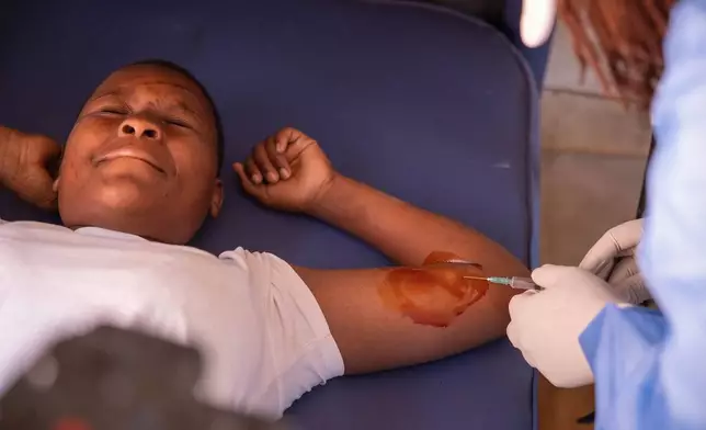 Chenai Mukucha reacts as a birth control implant is administered inside a caravan at Epworth Poly Clinic in Epworth, Zimbabwe, Tuesday, Aug. 25, 2026. (AP Photo/Aaron Ufumeli)