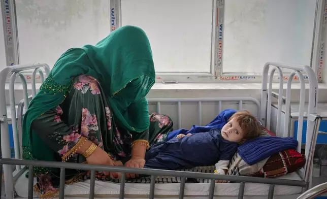 Malika, 25, tends to her 3-year-old daughter, Kalsoum, who has symptoms of malnutrition, in the malnutrition ward at Indira Gandhi children's hospital in Kabul, Afghanistan, Monday, Oct. 12, 2026. (AP Photo/Siddiqullah Alizai)