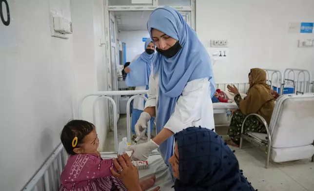 A health worker treats a child in the malnutrition ward at Indira Gandhi children's hospital in Kabul, Afghanistan, Monday, Oct. 12, 2026. (AP Photo/Siddiqullah Alizai)
