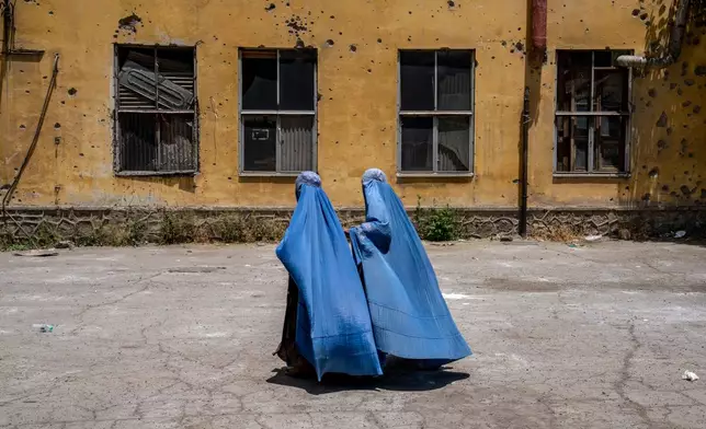 FILE - Women wait to receive food rations distributed by a humanitarian aid group in Kabul, Afghanistan, May 28, 2023. (AP Photo/Ebrahim Noroozi, File)