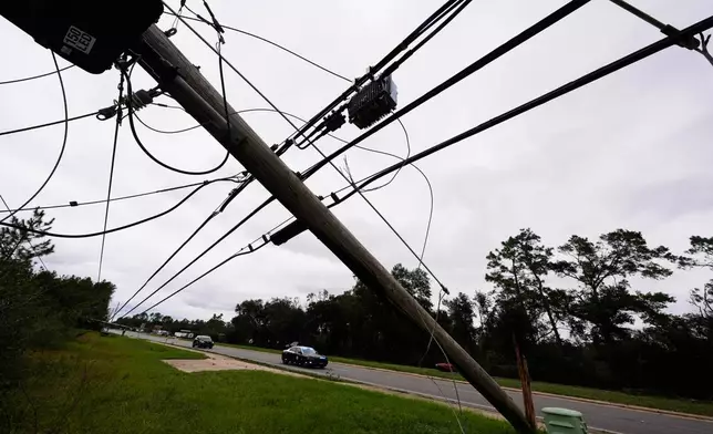 State troopers ride past downed power lines in the aftermath of Hurricane Isaias in Milton, Fla., Saturday, Oct. 10, 2026. (AP Photo/Gerald Herbert)