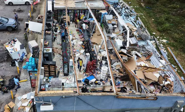 People salvage the contents of their destroyed mini mart in the aftermath of Hurricane Isaias in Milton, Fla., Saturday, Oct. 10, 2026. (AP Photo/Gerald Herbert)