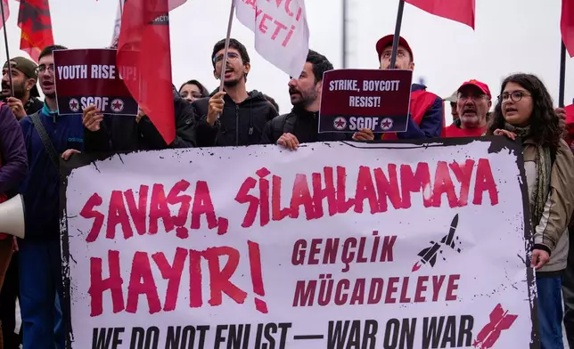 People shout slogans during a protest outside Haydarpasa port calling for the end of shipments to Israel, in Istanbul, Turkey, Friday, Oct. 30, 2026. The banner reads in Turkish: "No to war, no to armament!". (AP Photo/Emrah Gurel)