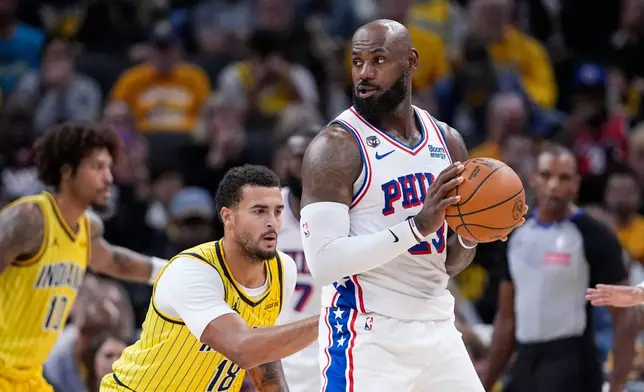 Indiana Pacers forward Jalen Slawson (18) defends Philadelphia 76ers forward LeBron James (23) during the first half of an NBA basketball game in Indianapolis, Wednesday, Oct. 28, 2026. (AP Photo/Michael Conroy)
