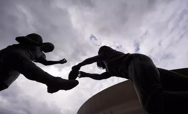 The Rebirth Statue is seen with storm clouds outside the Superdome, before an NFL football game 20 years later between the New Orleans Saints and the Atlanta Falcons, in New Orleans, Monday, Oct. 5, 2026. The statue features New Orleans Saints Steve Gleason blocking a punt by Atlanta Falcons punter Michael Koenen, in the first Saints home game after Hurricane Katrina. (AP Photo/Gerald Herbert)