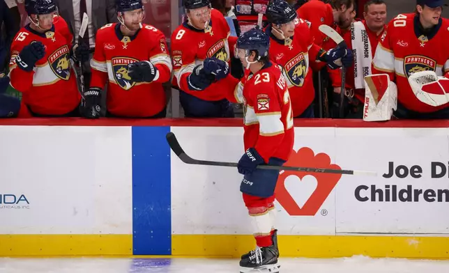 Florida Panthers center Carter Verhaeghe (23) celebrates with teammates after completing a hat trick during the second period of an NHL hockey game against the Seattle Kraken, Saturday, Oct. 17, 2026, in Sunrise, Fla. (AP Photo/David Santiago)