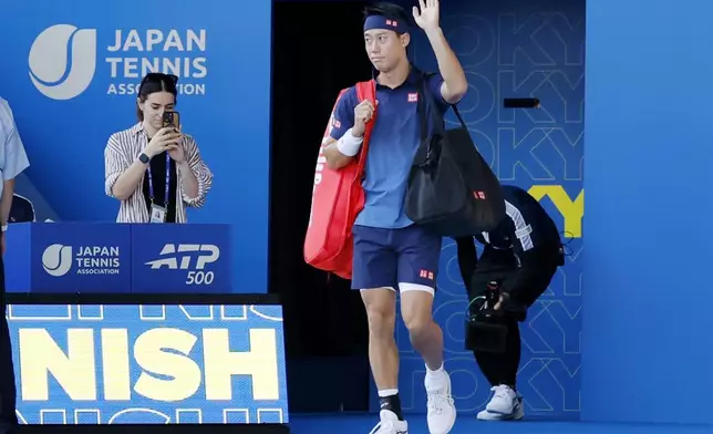 Japan's Kei Nishikori waves as he arrives at the court as he plays Frances Tiafoe in the first round of the Japan Open tennis in Tokyo, Thursday, Oct. 1, 2026. (Daiki Katagiri/Kyodo News via AP)