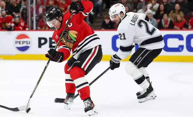 Chicago Blackhawks center Connor Bedard, left, and Los Angeles Kings center Scott Laughton (21) battle for the puck during the second period of an NHL hockey game, Tuesday, Oct. 27, 2026, in Chicago. (AP Photo/Jessie Alcheh)