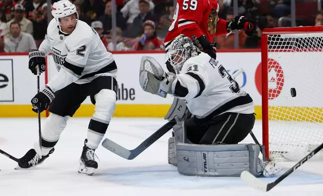 Los Angeles Kings goaltender Anton Forsberg (31) attempts to make a save against the Chicago Blackhawks as defenseman Brian Dumoulin (2) watches during the second period of an NHL hockey game, Tuesday, Oct. 27, 2026, in Chicago. (AP Photo/Jessie Alcheh)