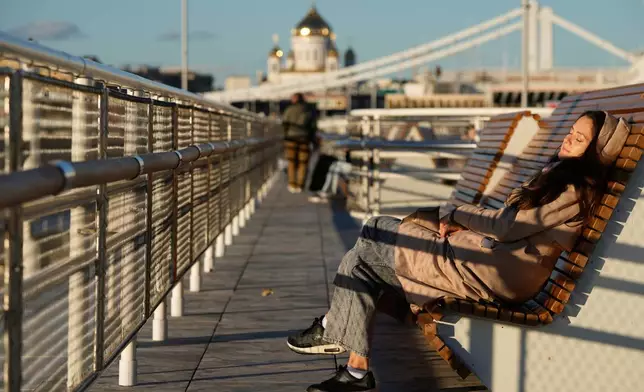 A woman enjoys warm weather in the Gorky park on a sunny day in Moscow, Wednesday, Oct. 7, 2026. (AP Photo/Pavel Bednyakov)