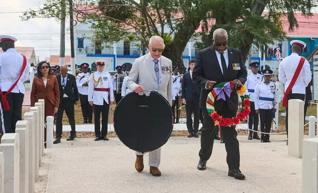 Britain's King Charles III, left, and Guyana's Prime Minister Mark Anthony Phillip, right, attend a wreath-laying ceremony at the Commonwealth War Graves in Georgetown, Guyana, Friday, Oct. 30, 2026. (AP Photo/Delano Williams)