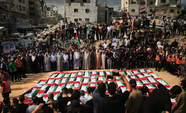 Mourners gather around the flag-draped remains of Palestinians killed in Israeli strikes during the war with Hamas after they were recovered from the rubble, during their funeral in Gaza City, Thursday, Oct. 1, 2026. (AP Photo/Yousef Al Zanoun)