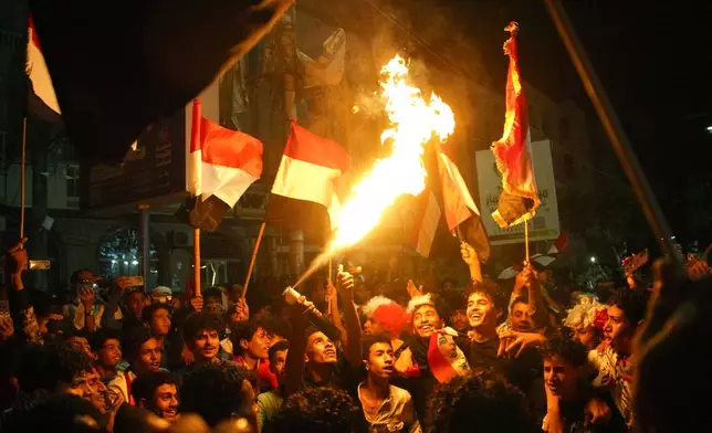 Yemenis wave national flags and light fires as they celebrate the 64th anniversary of the September 26 Revolution in Taiz, Yemen, Friday, Sept. 25, 2026. (AP Photo/Abdulnasser Alseddik)