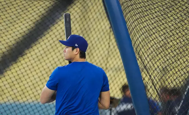 Los Angeles Dodgers' Shohei Ohtani enters the batting cage during a workout ahead of Game 3 of baseball's National League Championship Series against the Milwaukee Brewers, Tuesday, Oct. 13, 2026, in Los Angeles. (AP Photo/Jae C. Hong)