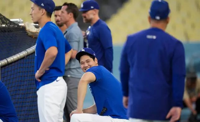 Los Angeles Dodgers' Shohei Ohtani smiles while waiting by the batting cage during a workout ahead of Game 3 of baseball's National League Championship Series against the Milwaukee Brewers, Tuesday, Oct. 13, 2026, in Los Angeles. (AP Photo/Jae C. Hong)