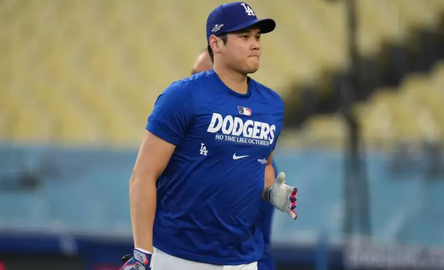 Los Angeles Dodgers' Shohei Ohtani walks toward the dugout during a workout ahead of Game 3 of baseball's National League Championship Series against the Milwaukee Brewers, Tuesday, Oct. 13, 2026, in Los Angeles. (AP Photo/Jae C. Hong)