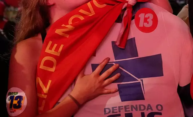 A supporter of President Luiz Inacio Lula da Silva kisses a cutout of him celebrating his victory in the presidential runoff in , Brazil, Sunday, Oct. 25, 2026.(AP Photo/Silvia Izquierdo)