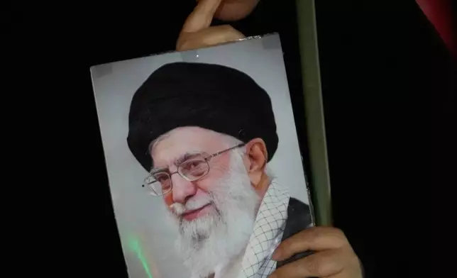 A demonstrator holds a portrait of the late Iranian Supreme Leader Ayatollah Ali Khamenei, who was killed in the U.S. and Israel strike on Feb. 28, during a pro-government gathering in Tehran, Iran, Tuesday, Oct. 27, 2026. (AP Photo/Vahid Salemi)