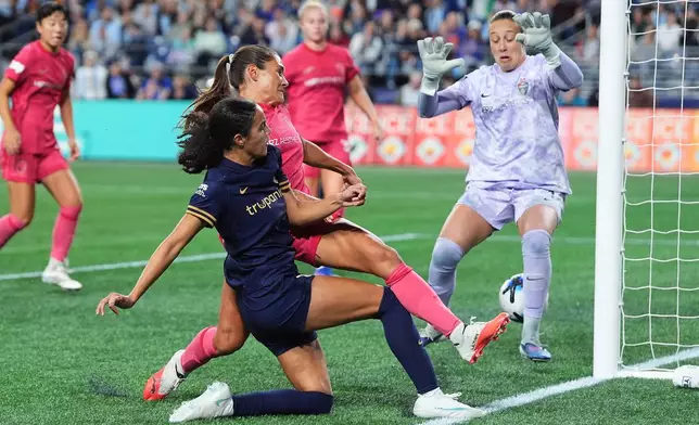 Seattle Reign FC defender Jordyn Bugg, left, tries to tip in the ball past North Carolina Courage midfielder Carly Wickenheiser, second from left, and goalkeeper Kailen Sheridan, right, but the ball goes wide on goal during the second half of an NWSL soccer match, Friday, Oct. 2, 2026, in Seattle. (AP Photo/Lindsey Wasson)
