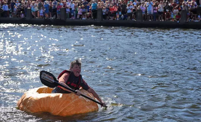 Laura Fairchild paddles a giant pumpkin to the finish line in the pumpkin regatta race during the annual Harvest Festival, Sunday, Oct. 11, 2026, in Stillwater, Minn. (AP Photo/Ellen Schmidt)