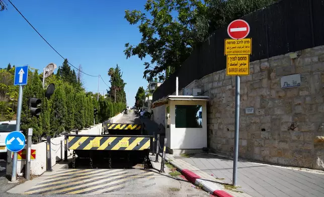 Barricades block the main road leading to British Consulate after the sign outside the consulate was taken down, in east Jerusalem, Thursday, Oct. 8, 2026. (AP Photo/Mahmoud Illean)