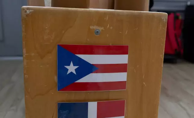 National flags representing Puerto Rico, the Dominican Republic and the United States are displayed on a classroom shelf as a child plays in the background at the John Cardinal O'Connor Center for Parent and Child Development, a Head Start center operated by The New York Foundling, in San Juan, Puerto Rico, Tuesday, Oct. 13, 2026. (AP Photo/Alejandro Granadillo)