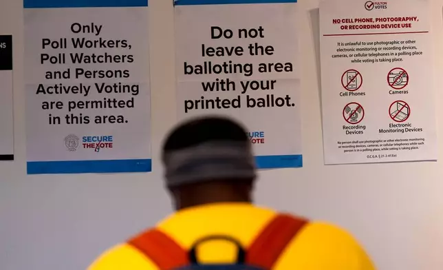 A man walks inside the The High Museum of Art voting center on the first day for early voting in Georgia, Tuesday, Oct. 13, 2026, in Atlanta. (AP Photo/Mike Stewart)