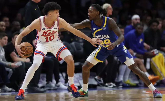 Brooklyn Nets' Nolan Traore, left, defends the ball from Indiana Pacers' Quenton Jackson, right, during the first half of an NBA basketball game Sunday, Oct. 25, 2026, in New York. (AP Photo/Pamela Smith)
