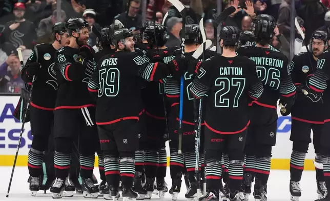 The Seattle Kraken celebrate after beating the Detroit Red Wings in a shootout in an NHL hockey game Tuesday, Oct. 20, 2026, in Seattle. (AP Photo/Lindsey Wasson)