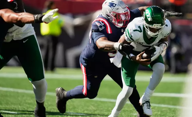 New England Patriots defensive tackle Christian Barmore, left, sacks New York Jets quarterback Geno Smith (7) during the first half of an NFL football game in Foxborough, Mass., Sunday, Oct. 18, 2026. (AP Photo/Charles Krupa)