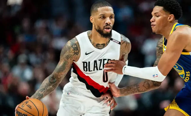 Portland Trail Blazers guard Damian Lillard (0) brings the ball up the court against Golden State Warriors guard Will Richard, right, during the first half of a preseason NBA basketball game on Wednesday, Oct. 7, 2026, in Portland, Ore. (AP Photo/Ali Gradischer)