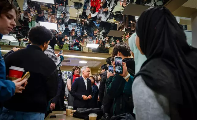 Canada Prime Minister, center, meets with University of Calgary students in Calgary, Alberta, Thursday, Oct. 15, 2026. (Jeff McIntosh/The Canadian Press via AP)