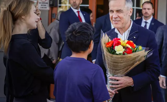 Canada Prime Minister Mark Carney, right, meets with supporters at a restaurant in Calgary, Canada, Thursday, Oct. 15, 2026. (Jeff McIntosh/The Canadian Press via AP)