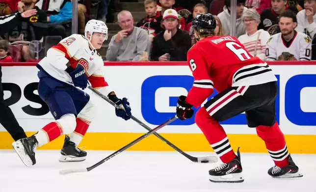 Florida Panthers left wing Sandis Vilmanis, left, skates with the puck against Chicago Blackhawks defenseman Sam Rinzel (6) during the first period of an NHL hockey game, Sunday, Oct. 25, 2026, in Chicago. (AP Photo/Harry Figiel)