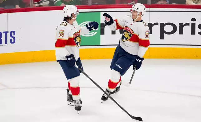 Florida Panthers center Lars Eller, right, celebrates with center Carter Verhaeghe, left, after scoring the winning goal during the third period of an NHL hockey game against the Chicago Blackhawks, Sunday, Oct. 25, 2026, in Chicago. (AP Photo/Harry Figiel)