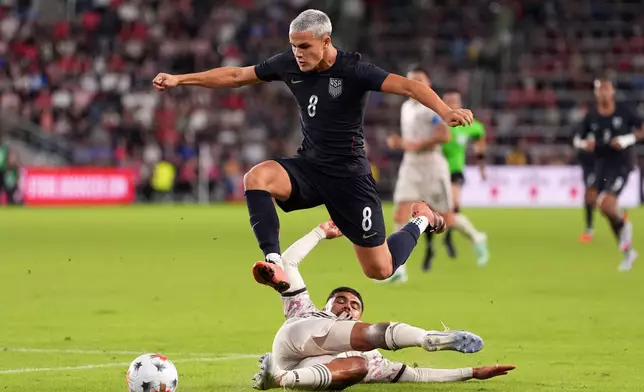United States' Cavan Sullivan (8) leaps over Chile's Paulo Díaz while contolling the ball during the second half of an international friendly soccer match Tuesday, Sept. 29, 2026, in St. Louis. (AP Photo/Jeff Roberson)