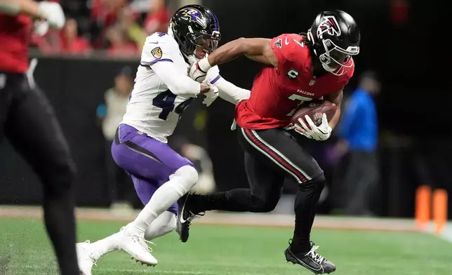 Atlanta Falcons running back Bijan Robinson (7) tries to break a tackle by Baltimore Ravens cornerback Marlon Humphrey (44) during the second half of an NFL football game, Sunday, Oct. 11, 2026, in Atlanta. (AP Photo/Mike Stewart)
