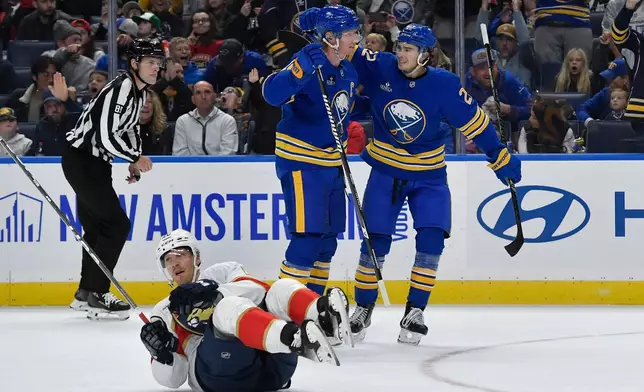 Buffalo Sabres defenseman Rasmus Dahlin, center, celebrates with right wing Jack Quinn, right, after scoring as Florida Panthers center Lars Eller (20) lays on the ice during the first period of an NHL hockey game Monday, Oct. 12, 2026, in Buffalo, N.Y. (AP Photo/Adrian Kraus)