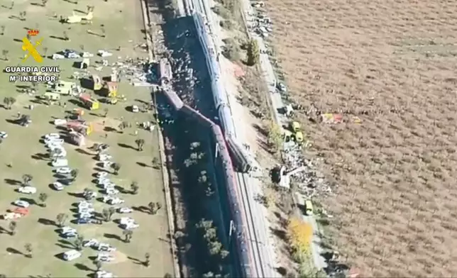 This framegrab taken from a video provided by Guardia Civil shows an aerial view of carriages and first responders on the site of a collision between two trains in Urda, Spain, Wednesday Oct. 28, 2026. (Guardia Civil via AP)