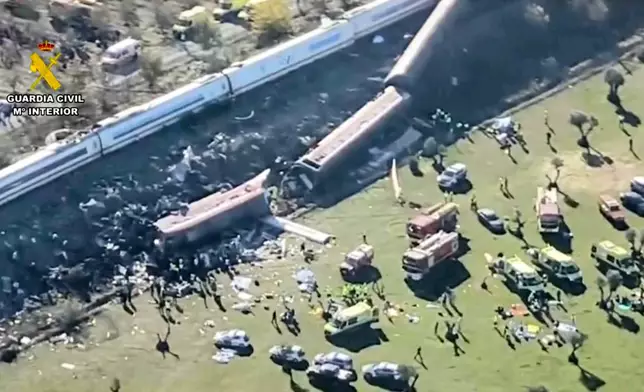 This framegrab taken from a video provided by Guardia Civil shows an aerial view of carriages and first responders on the site of a collision between two trains in Urda, Spain, Wednesday Oct. 28, 2026. (Guardia Civil via AP)