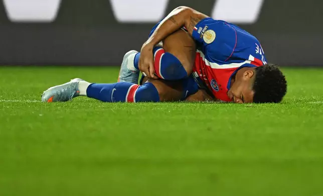 PSG's Desire Doue lies on the pitch in pain during the French League One soccer match between Paris Saint-Germain and Lyon in Paris, Monday, Oct. 26, 2026. (AP Photo/Emma Da Silva)