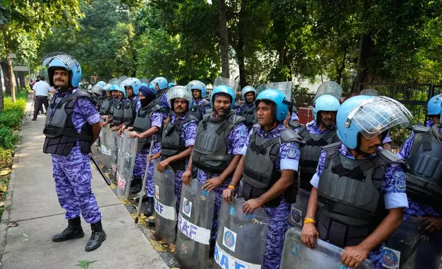 Security personnel watch as workers of India's opposition Congress party gather for a march toward the Supreme Court demanding the resignation of Chief Election Commissioner Gyanesh Kumar in New Delhi, India, Monday, Oct. 12, 2026. (AP Photo/Manish Swarup)