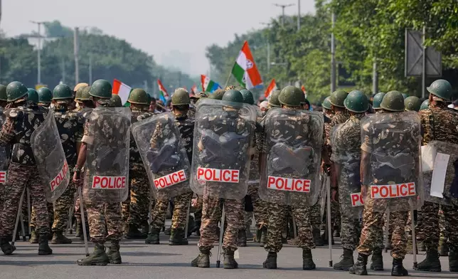 Security personnel in riot gear arrive to escort workers of India's opposition Congress party as they gather for a march toward the Supreme Court demanding the resignation of Chief Election Commissioner Gyanesh Kumar in New Delhi, India, Monday, Oct. 12, 2026. (AP Photo/Manish Swarup)