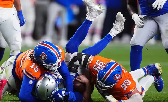 Denver Broncos defensive end Zach Allen (99) sacks Seattle Seahawks quarterback Sam Darnold with Broncos linebacker Nik Bonitto (15) during the second half of an NFL football game in Denver, Thursday, Oct. 15, 2026. (AP Photo/David Zalubowski)