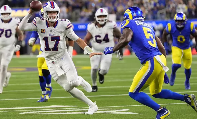 Buffalo Bills quarterback Josh Allen, left, runs the ball as Los Angeles Rams safety Kamren Kinchens defends during the second half of an NFL football game, Monday, Oct. 12, 2026, in Inglewood, Calif. (AP Photo/Gregory Bull)